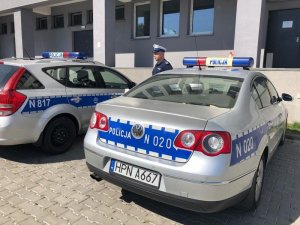 Policjant stoi przy radiowozie