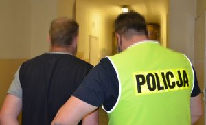 Policjant prowadzi zatrzymanego