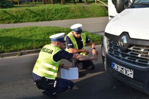 Policjanci w trakcie oględzin auta biorącego udział w wypadku