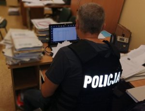 Policjant przeprowadza oględziny dokumentów