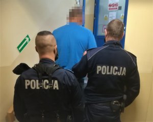 Policjanci prowadzą zatrzymanego