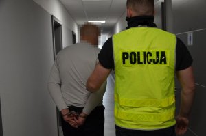 Policjant prowadzi zatrzymanego