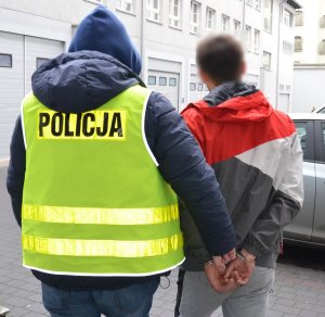 Policjant prowadzi zatrzymanego