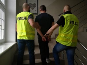 Policjanci prowadzą zatrzymanego