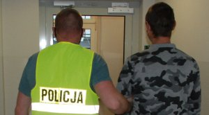 Policjant prowadzi zatrzymanego