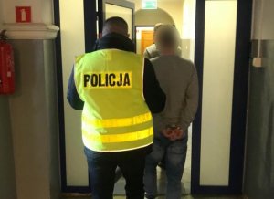 Policjant prowadzi zatrzymanego