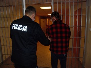 Policjant prowadzi zatrzymanego