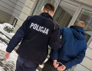 policjant prowadzi zatrzymanego