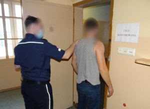 Policjant prowadzi zatrzymanego