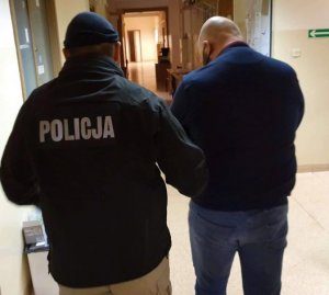 Policjant prowadzi zatrzymanego