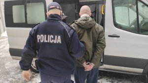 Policjant prowadzi zatrzymanego