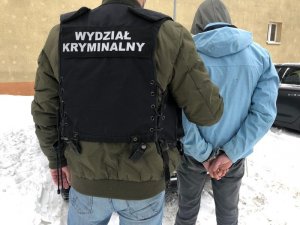 Policjant prowadzi zatrzymanego