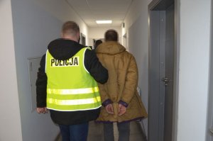 policjant prowadzi zatrzymanego