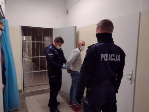 Policjant prowadzi zatrzymanego