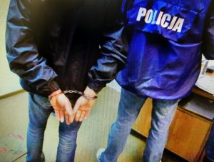 policjant prowadzi zatrzymanego