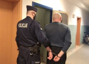 policjant prowadzi zatrzymanego