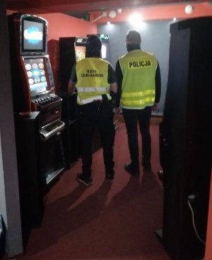 policjanci pracują przy sprawie z automatami