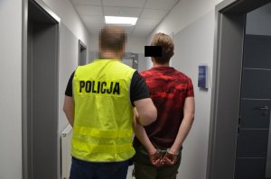 Policjant prowadzi zatrzymanego