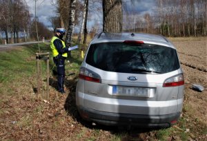 policjant i uszkodzony samochód