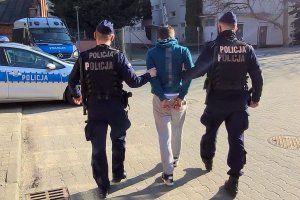 policjanci prowadzą zatrzymanego