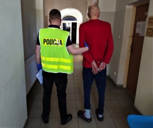 policjant prowadzi zatrzymanego