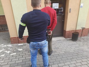 Policjant prowadzi zatrzymanego