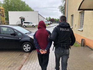 Policjant prowadzi zatrzymanego