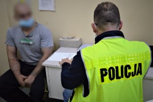 POLICJANT prowadzi czynności z zatrzymanym