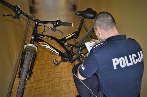 policjant z zabezpieczonym rowerem