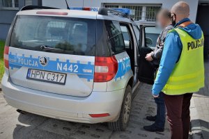 policjant wprowadza zatrzymanego do radiowozu