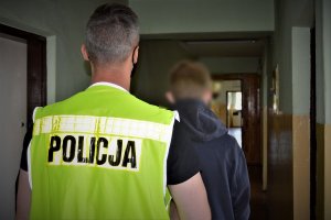 policjant z zatrzymaną kobietą i mężczyzną