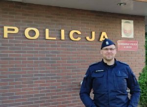 policjant stoi przed budynkiem komisariatu w Ustce