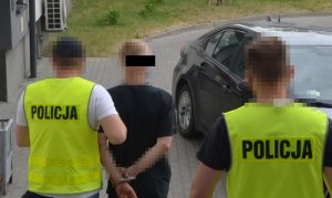 Policjanci prowadzą zatrzymanego