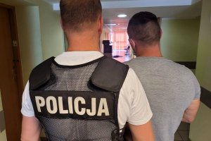 policjant prowadzi zatrzymanego