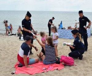policjanci na plaży prowadzą działania bezpieczna plaża