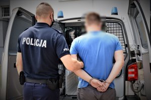 policjant w trakcie przesłuchania zatrzymanego i policjant prowadzący zatrzymanego do radiowozu