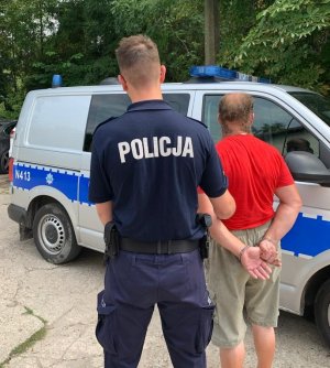 policjanci prowadzą zatrzymanych do radiowozu