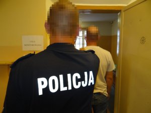 policjant z zatrzymanym za malowanie graffiti na pociągu oraz z zabezpieczonymi farbami