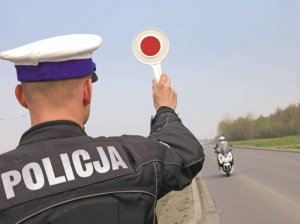 policjant ruchu drogowego w trakcie pomiaru prędkości oraz zatrzymywania pojazdu lizakiem