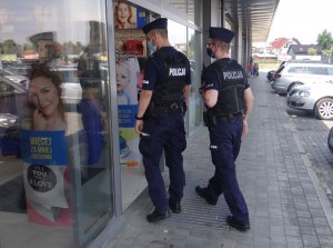 policjanci kontrolujący placówkę handlową