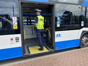 policjant wchodzący do autobusu na kontrolę covidową