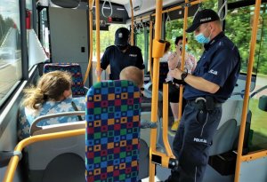 policjanci w trakcie kontroli stosowania się do obostrzeń w autobusie