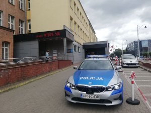 policjanci stoją przy radiowozie