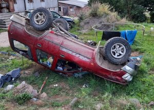 policjanci pracują na miejscu wypadku. Samochód leżący w rowie