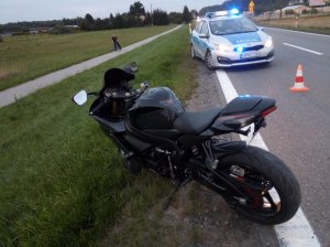 policjanci pracują na miejscu wypadku. Samochód leżący w rowie