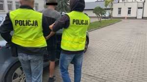 policjanci prowadzą zatrzymanego mężczyzne