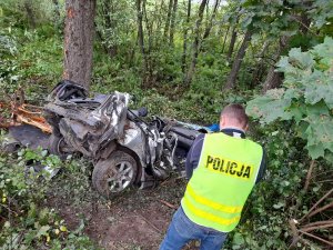 policjant stoi przy wraku rozbitego samochodu