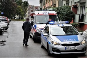 radiowóz stoi na jezdni, na zdjęciu widać też policjanta i świadka