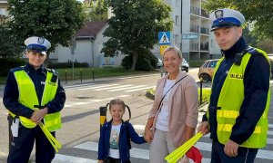 Policjanci rozdają odblaski w pobliżu szkoły i przejść dla pieszych