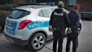 policjanci prowadzą zatrzymanego